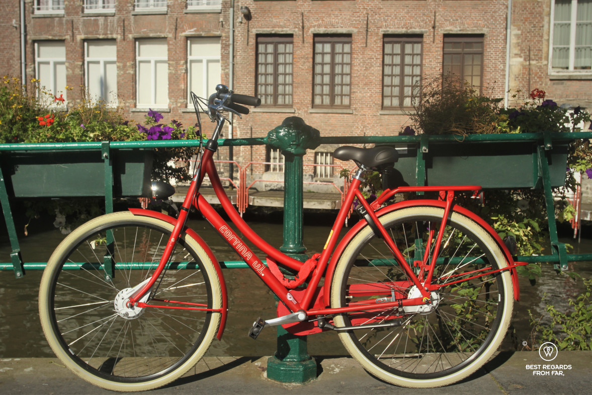 Red bike in front of a canal in Ghent