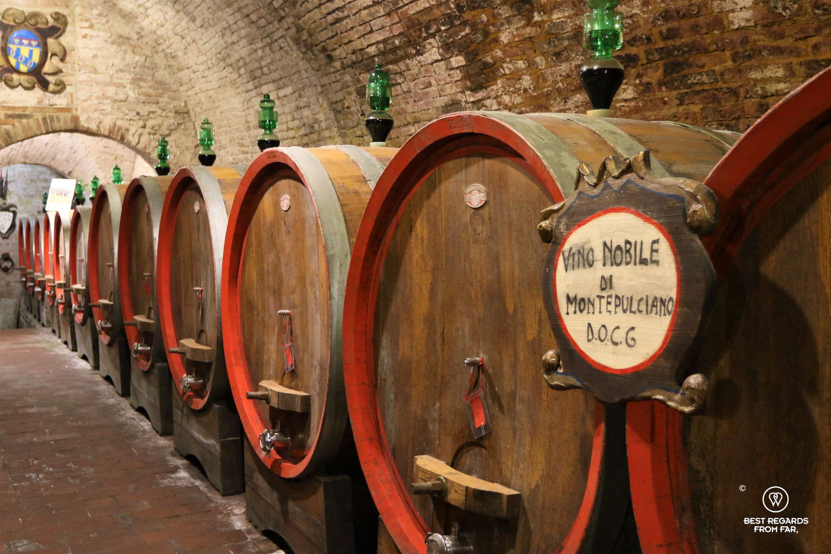 Oak wine barrels in a brick vaulted wine cellar in Italy