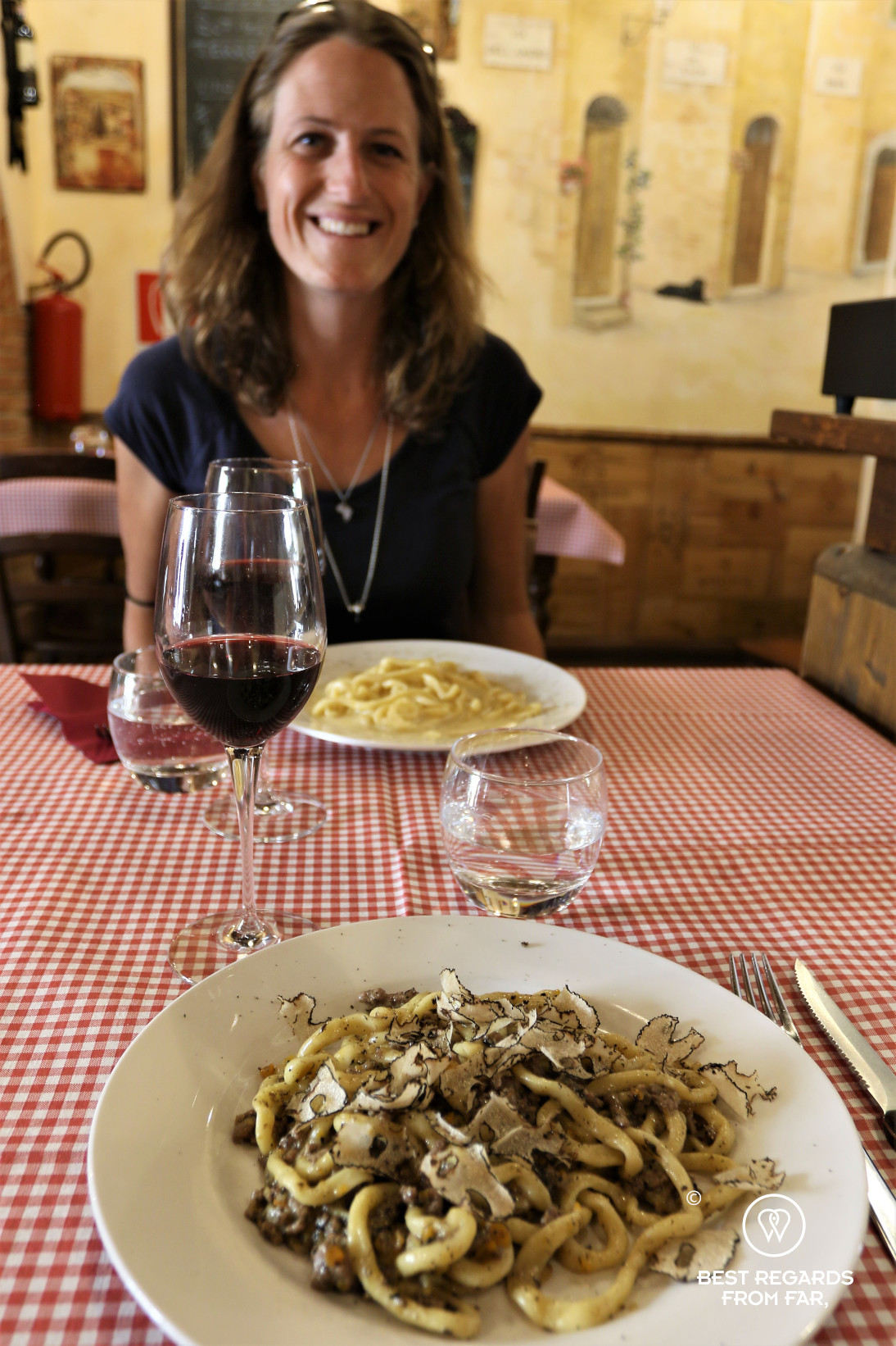 Woman smiling in an Italian restaurant with a table set with local speacialties