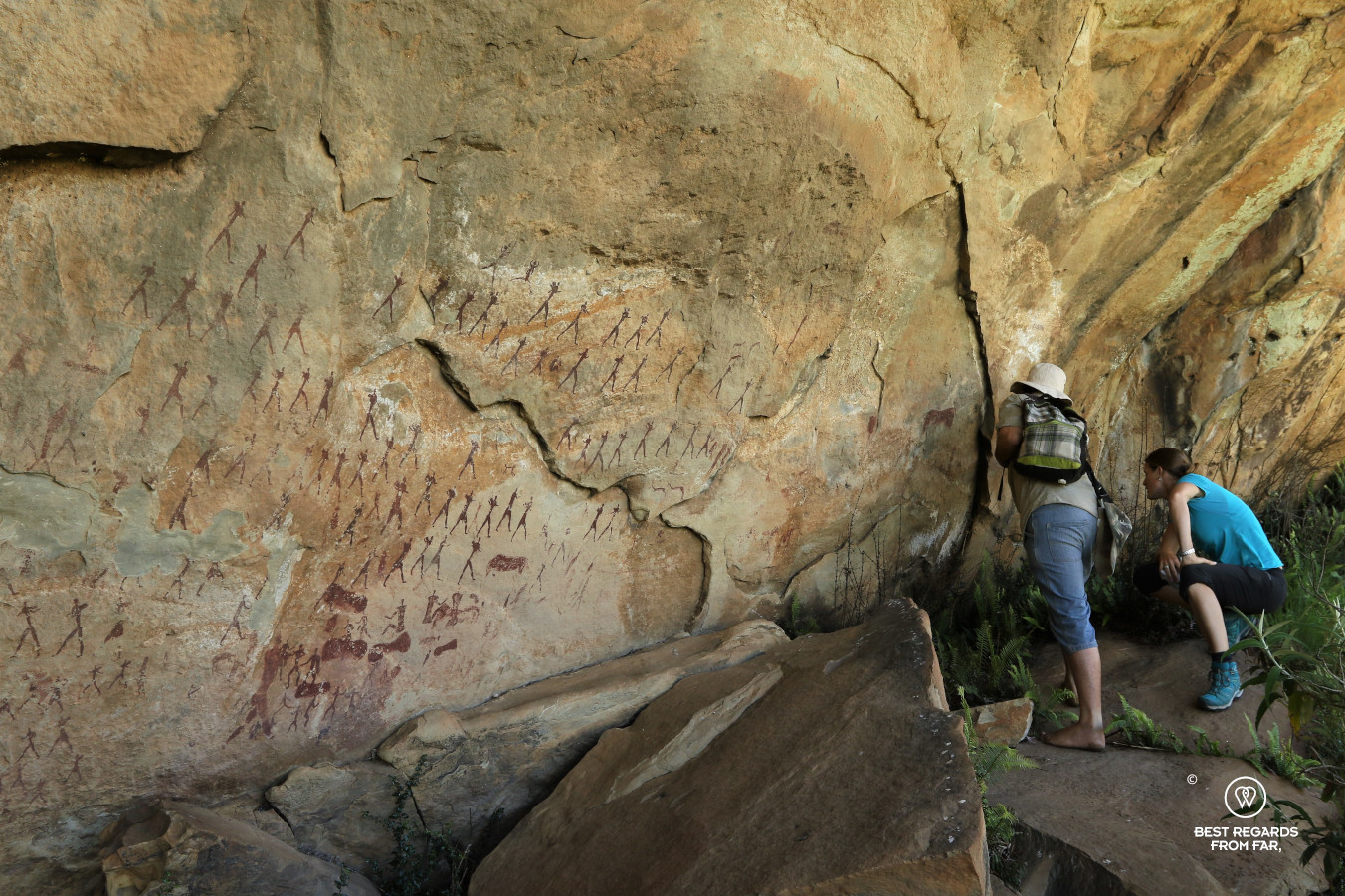 Hikers studying Bushmen rock art in the Drakensberg, South Africa.