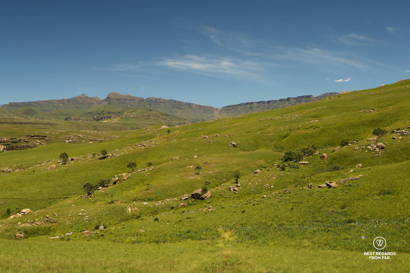 Sani Pass in the in the background with the green rolling hills of the Drakensberg.