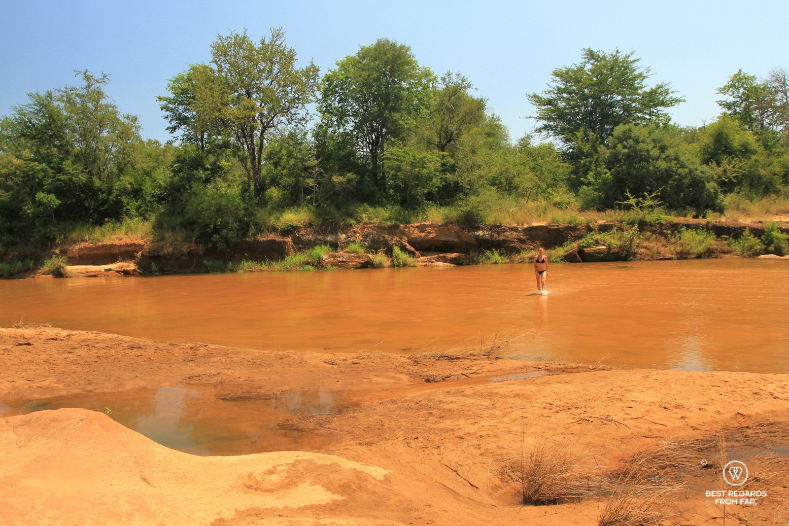 Person walking out of the red Selati River, Greater Kruger, South Africa