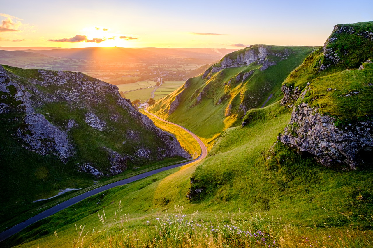 Road winding through Peak District, UK, at sunset.