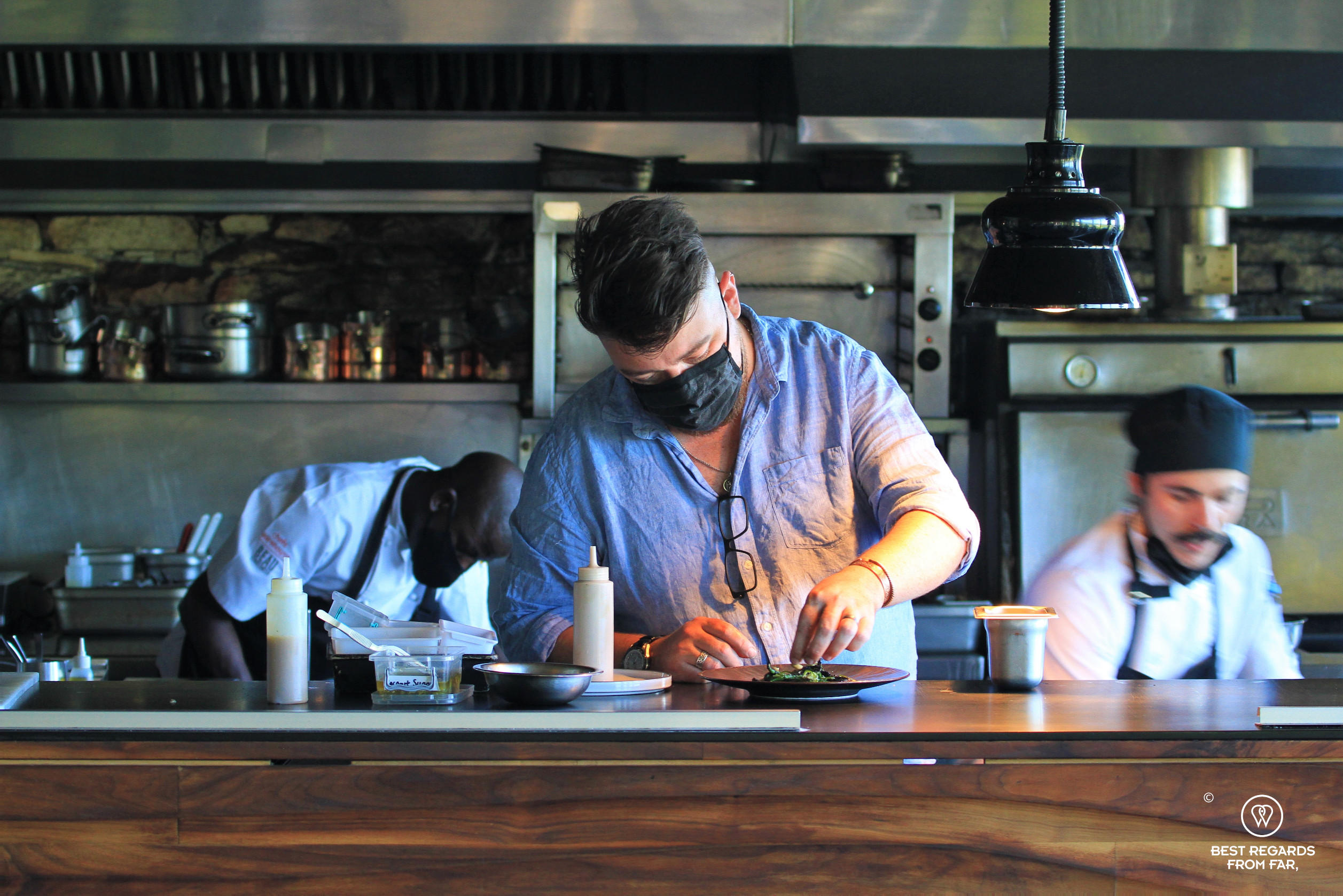 Chef Ivor Jones plating in the open kitchen of the Chefs Warehouse Beau Constantia