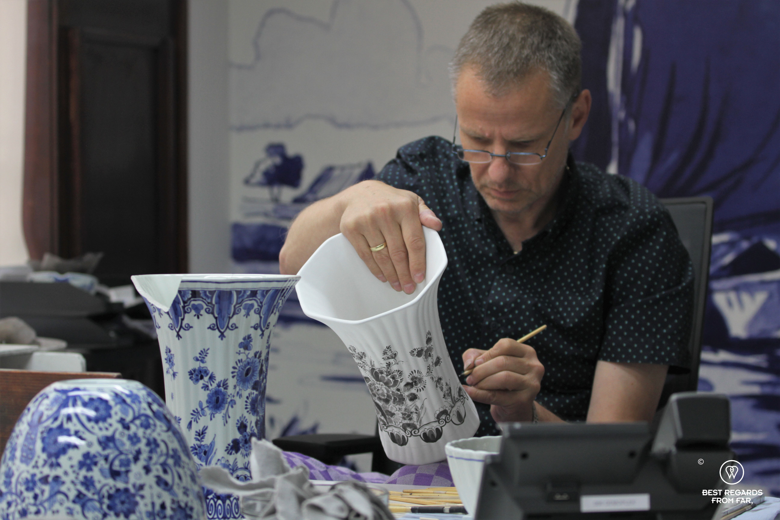 Master painter hand-painting a vase, the Royal Delft museum, the Netherlands