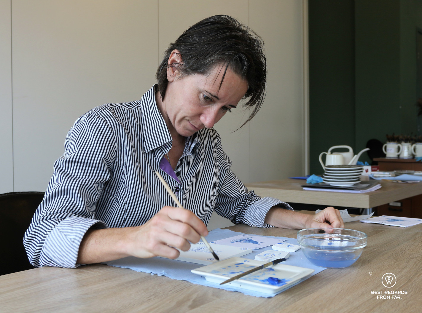 Author Claire Lessiau focusing to paint during a tile painting workshop at Royal Delft, the Netherlands