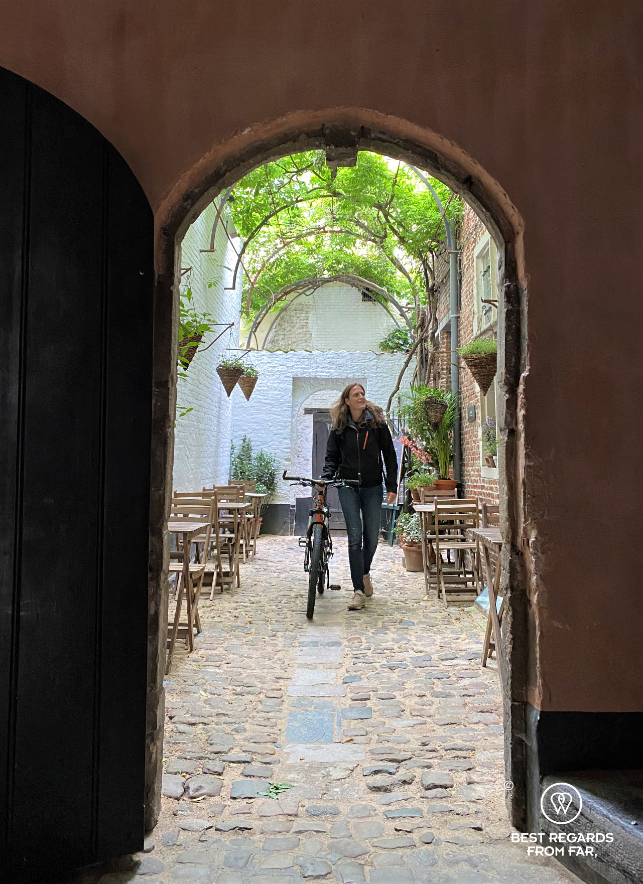 Biker going through Vlaeykensgang medieval street Antwerp, Belgium