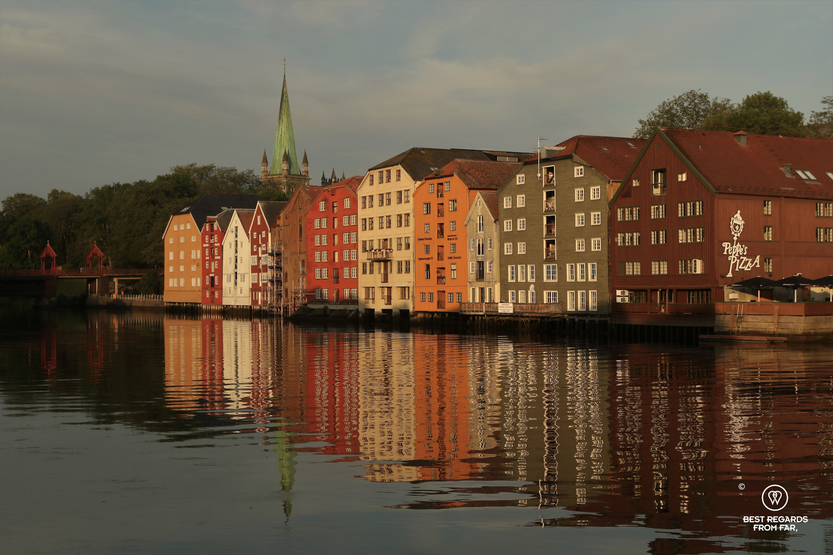 The colourful wood warehouses on stilts of Bryggen in Trondheim reflecting in the water