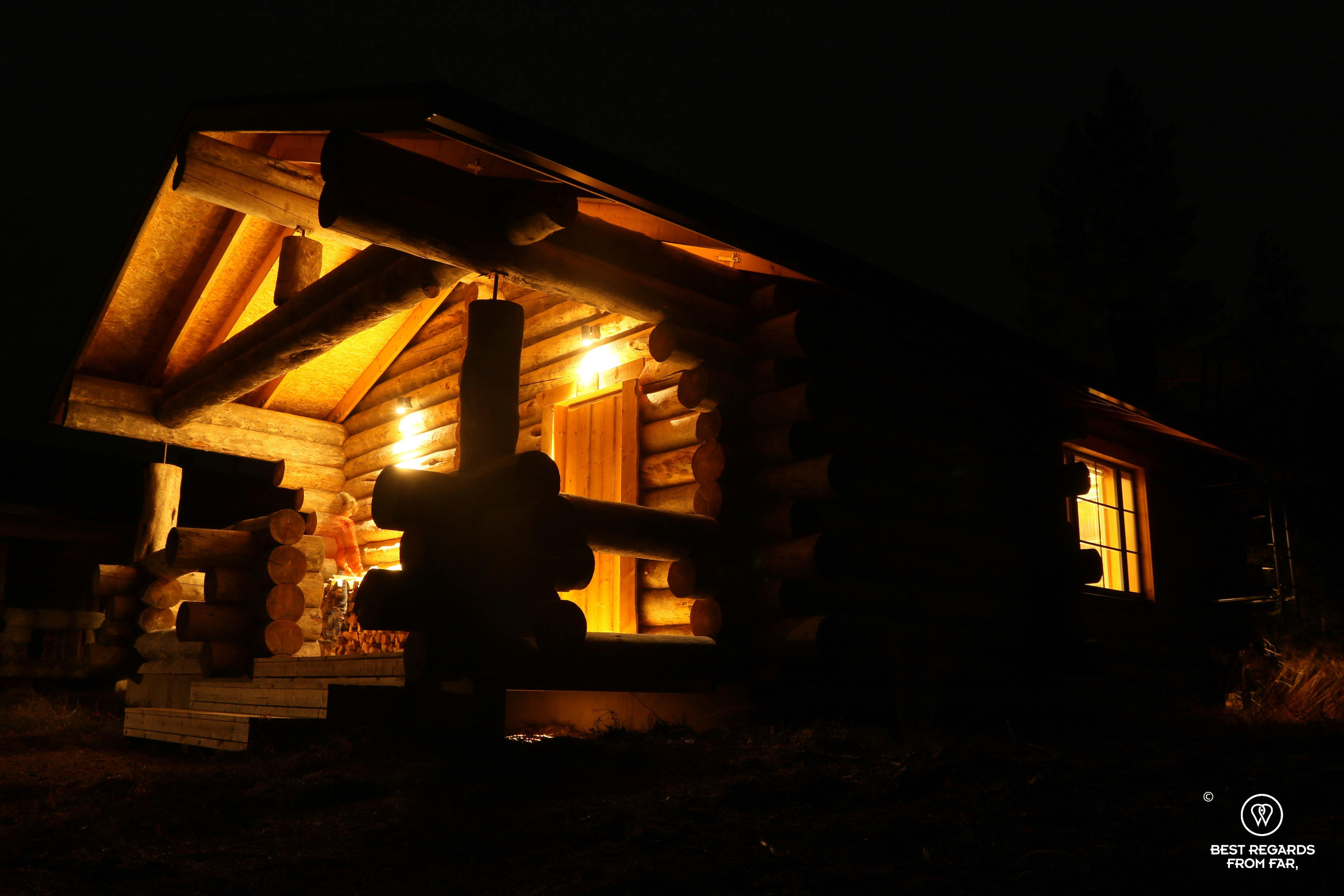 Private log-house by night at Wilderness Muotka Nellim, Lapland