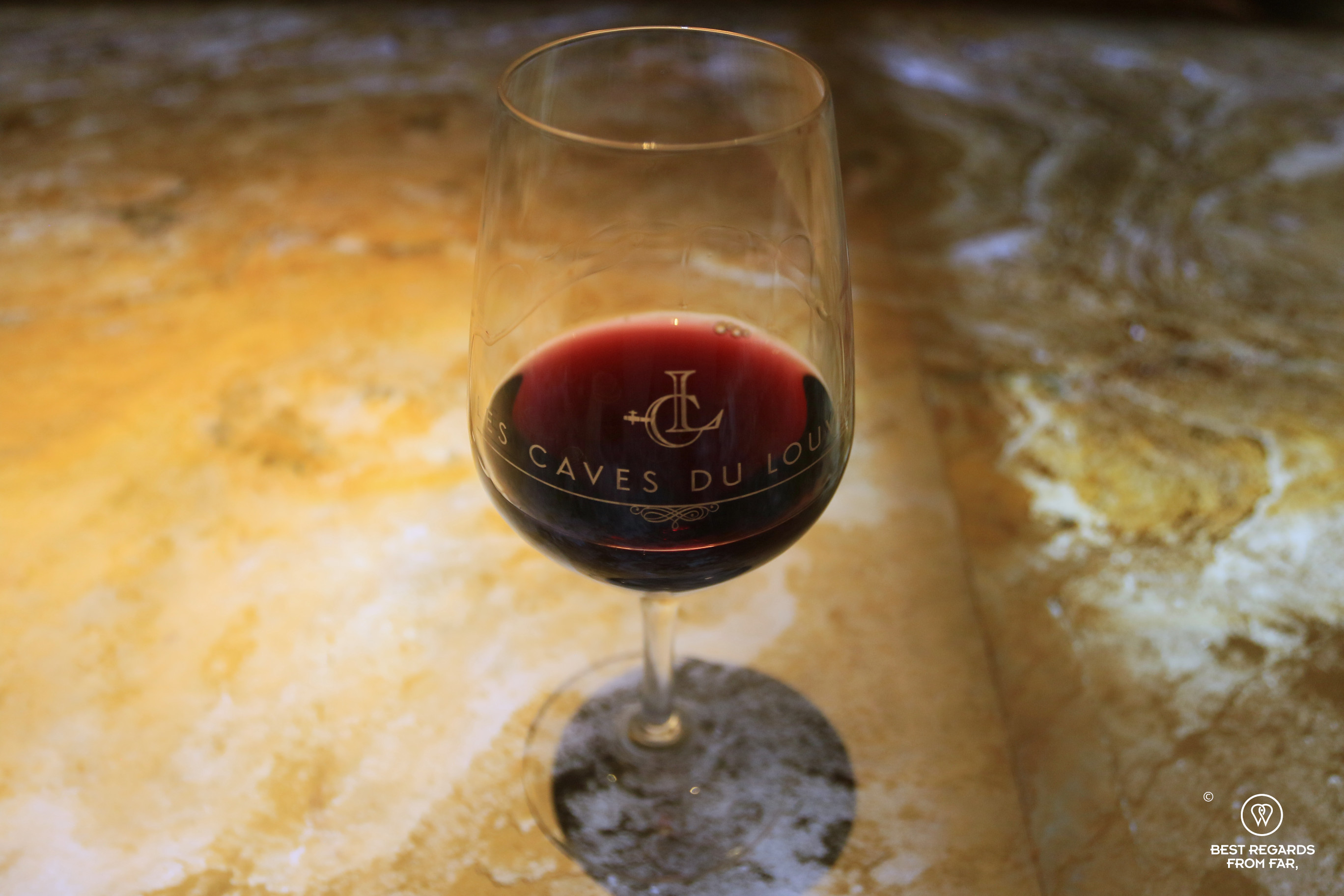 Glass of red wine for a tasting at Les caves du Louvre