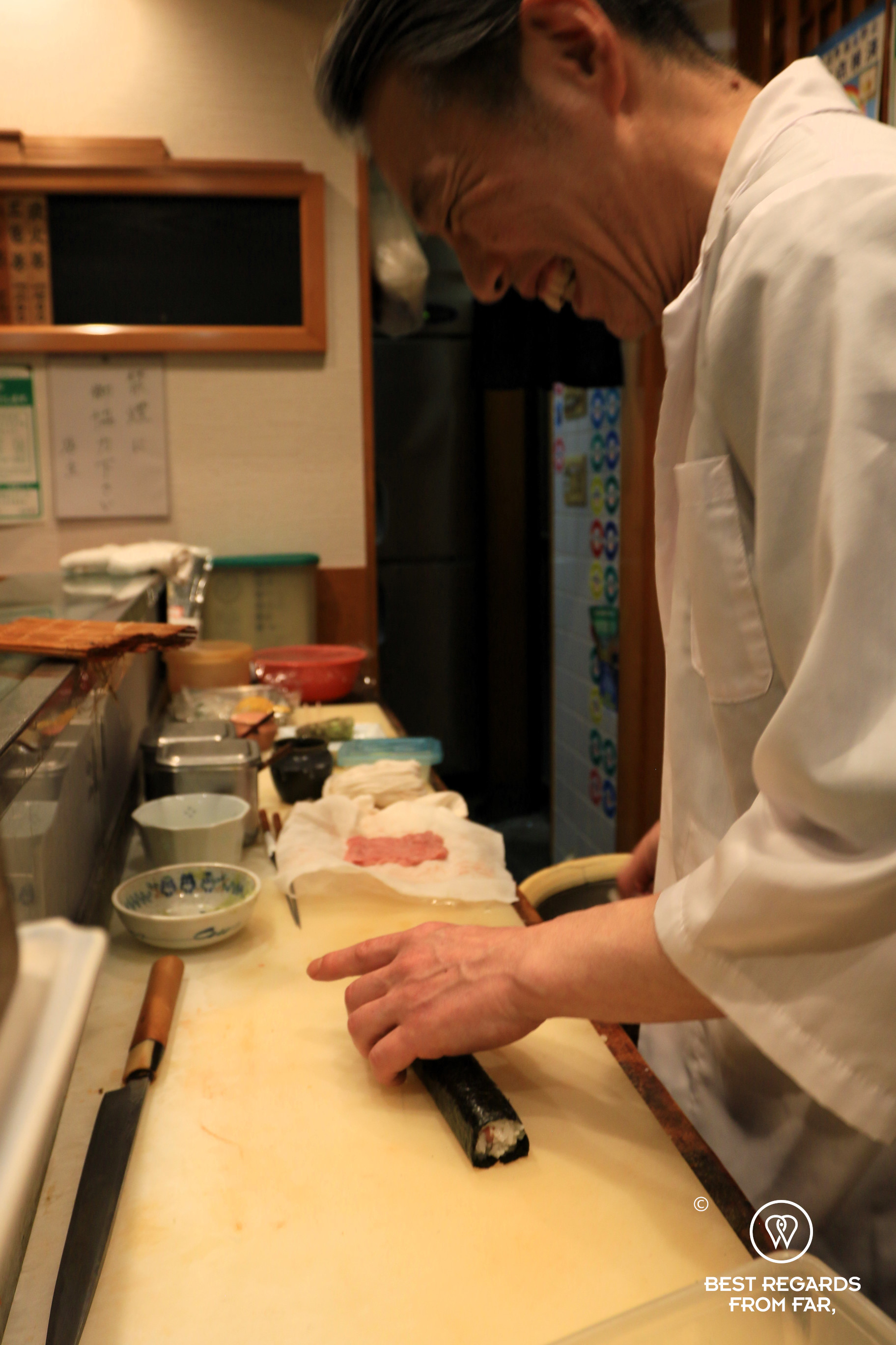 Sushi chef rolling maki in his sushiya