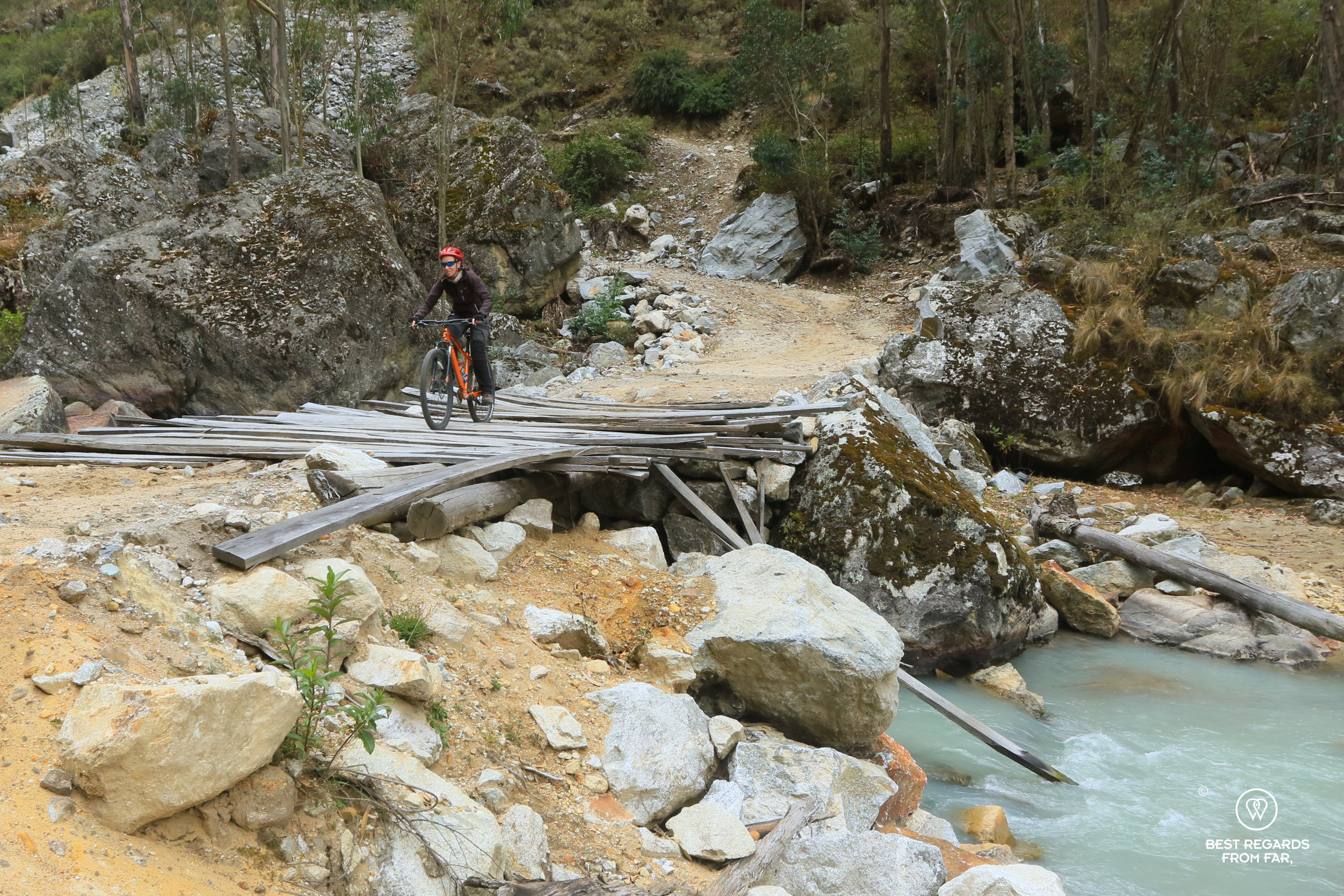 Woman crossing a wooden bridge when downhill mountain biking, Cordillera Blanca, Peru