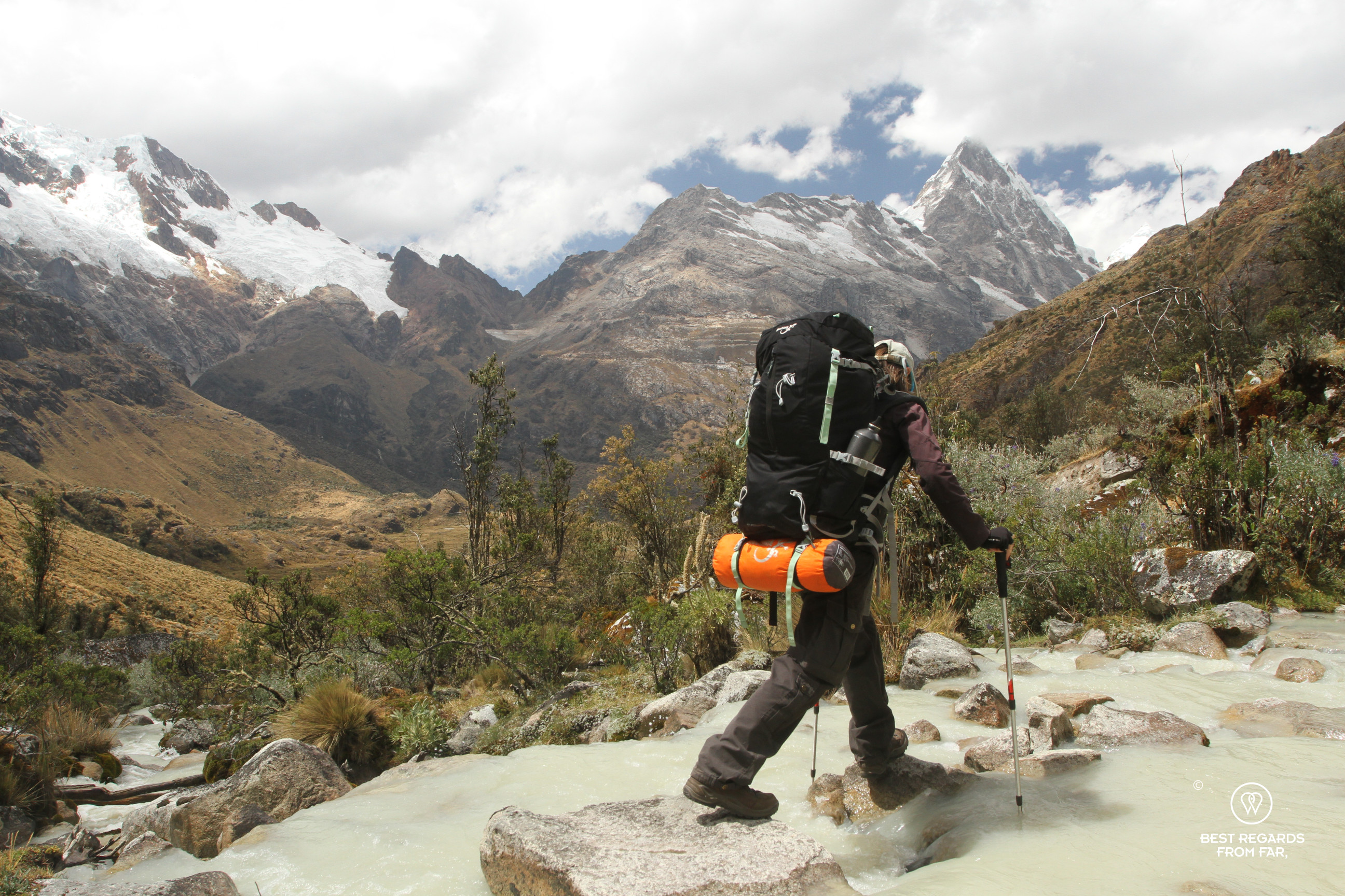 Woman crossing a river in the Peruvian Andes