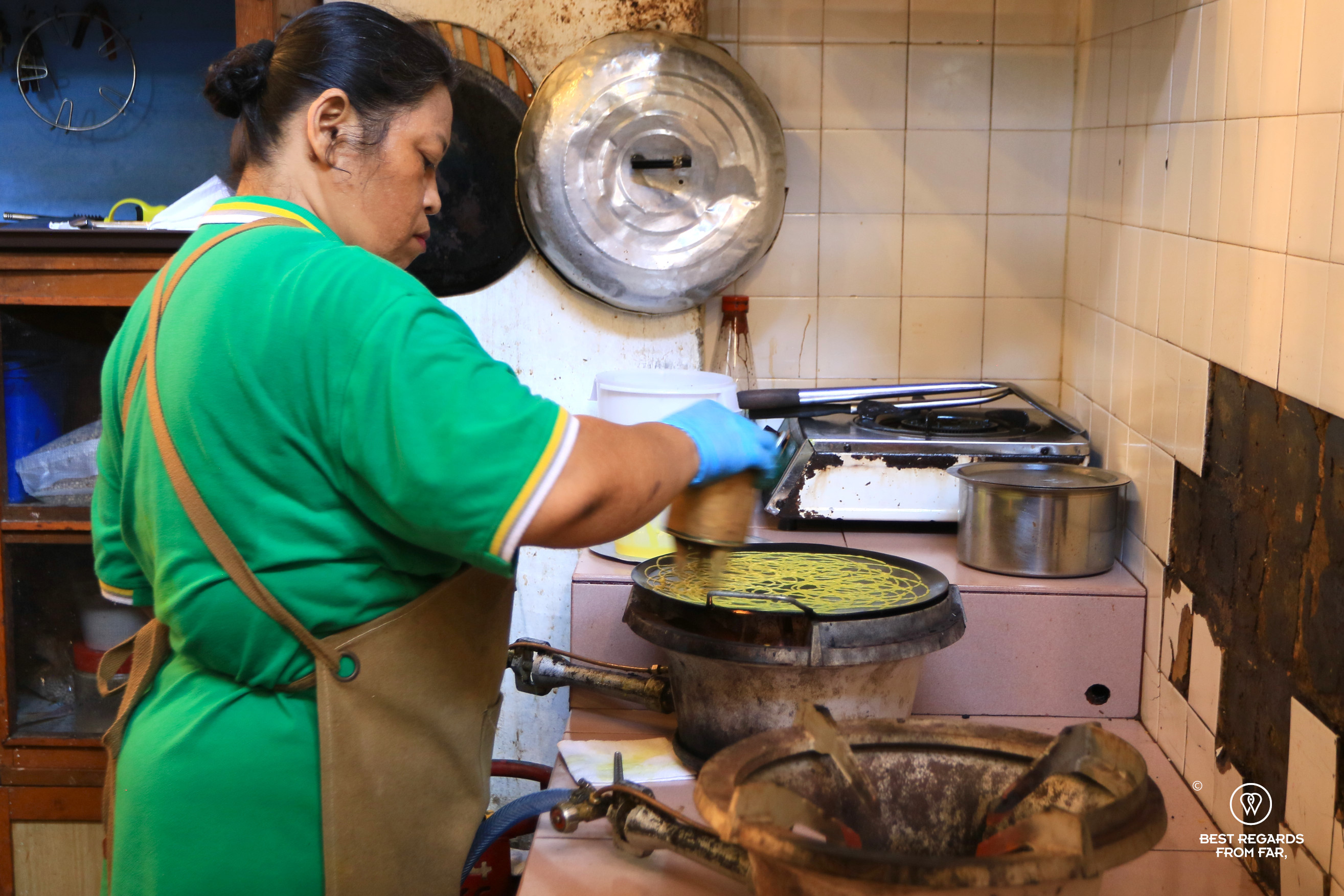 Woman making Roti Jala Nyonya cuisine.