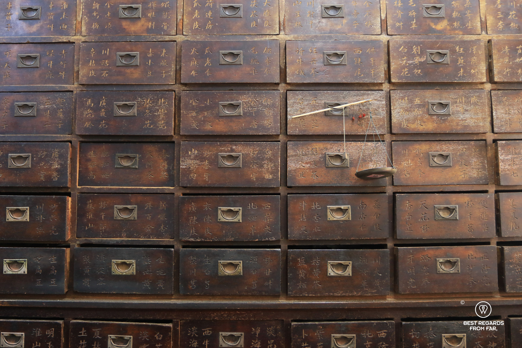Wooden drawers with Chinese characters of a cabinet in a Chinese pharmacy.