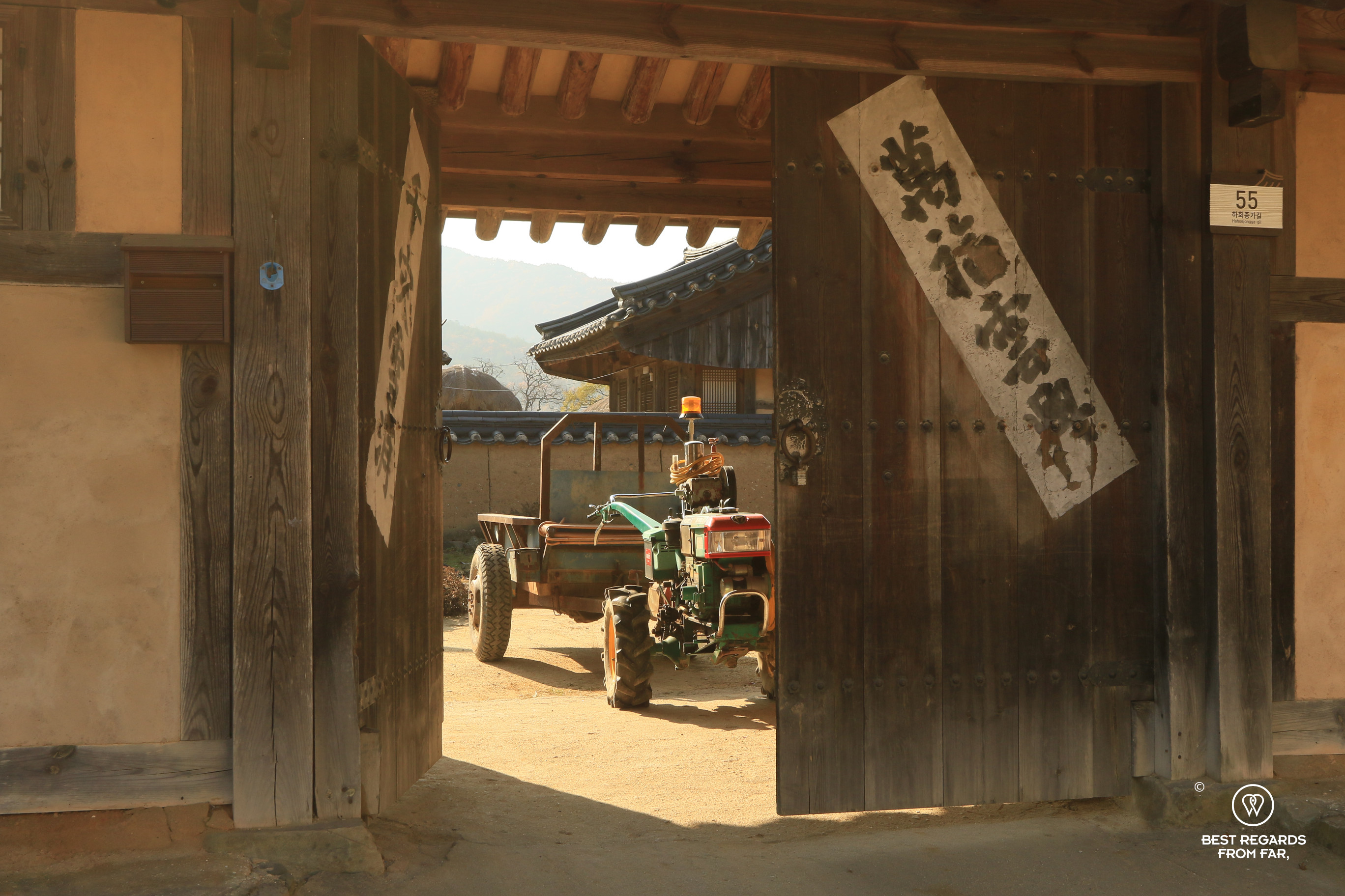 Tractor seen through the traditional wooden door of a hanok house in Hahoe folk village.