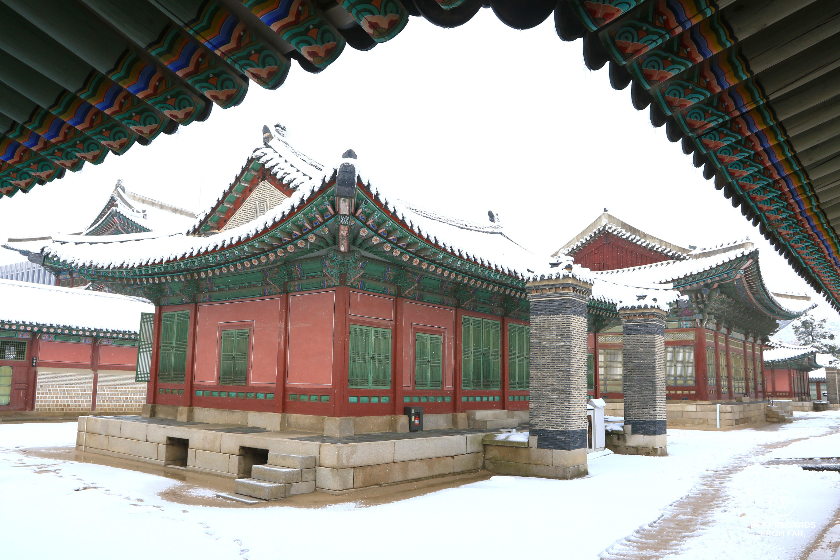 Red buildings covered in snow at the Gyeongbokgung Palace in Seoul and framed.