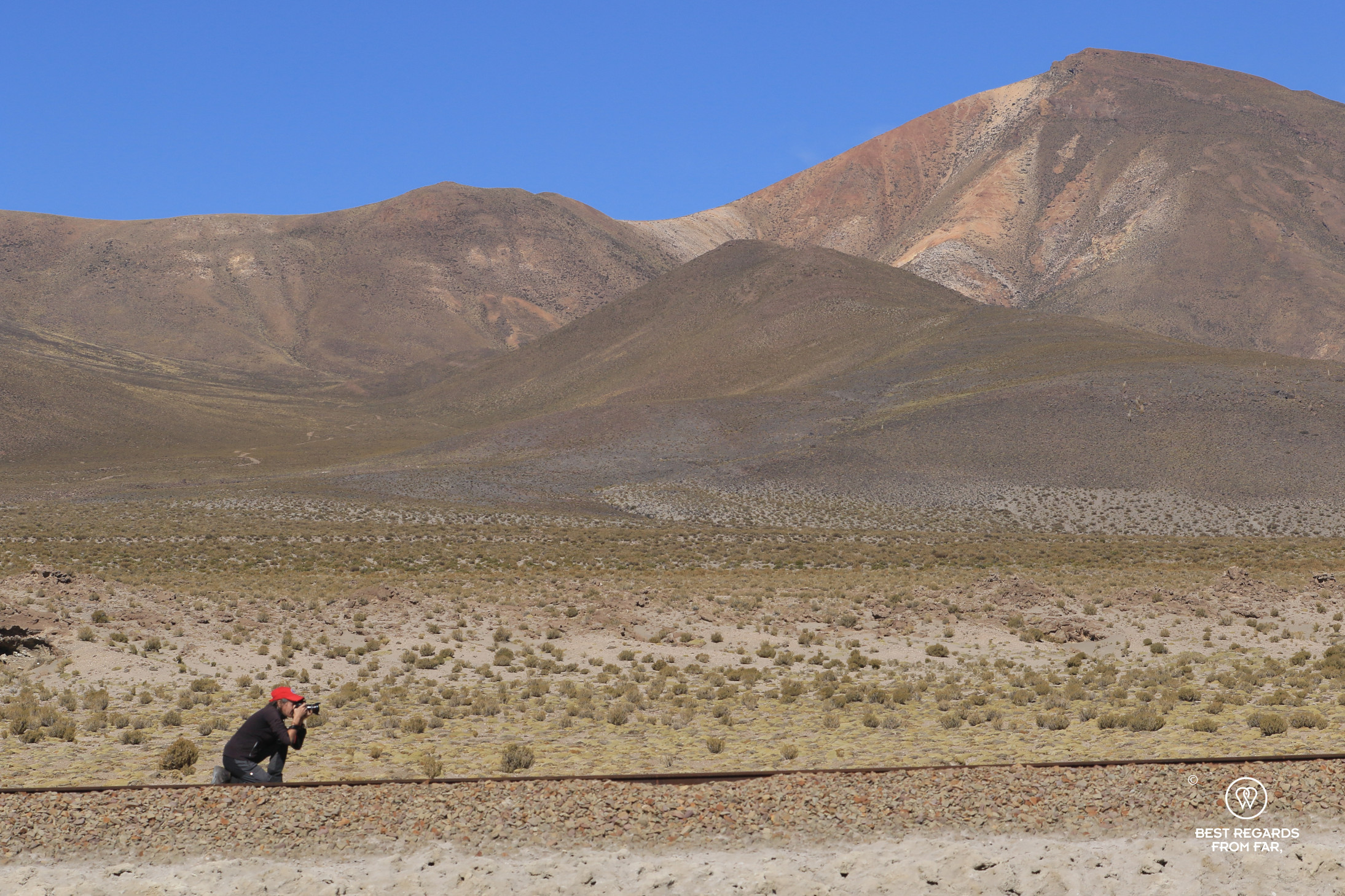 Photographer Claire Lessiau taking a phot of the train tracks in the Salar de Chiguana in Bolivia.