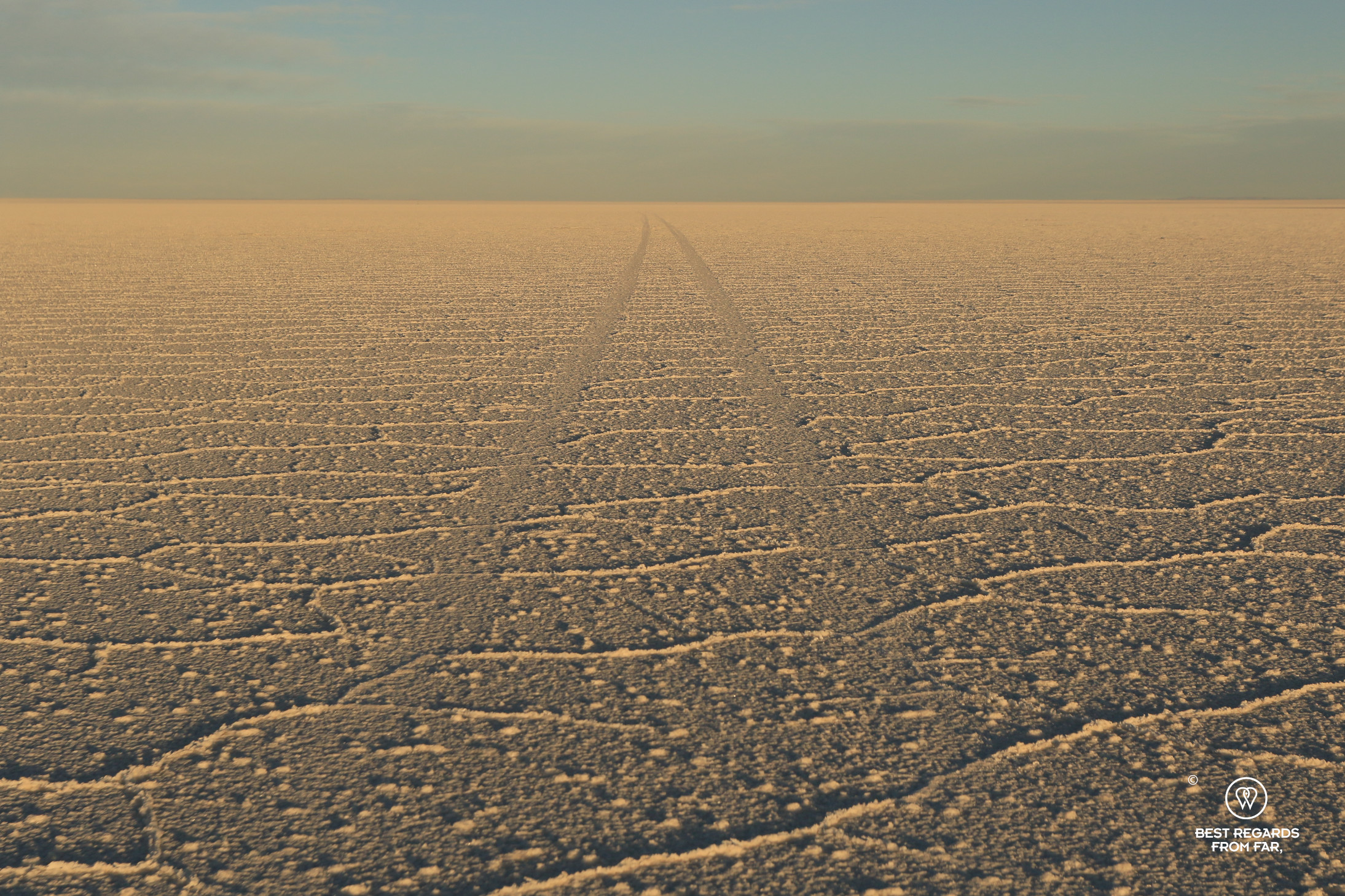 Sunset over the Salar de Uyuni and 4x4 tracks.