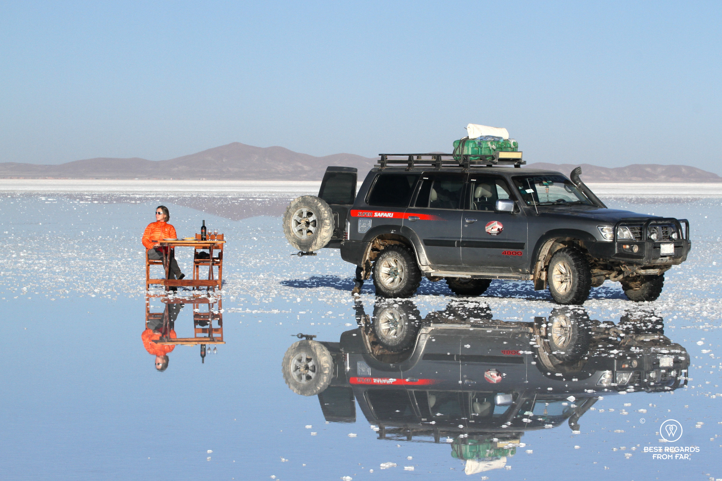 Reflection of 4x4 and photographer Claire Lessiau in the Salar de Uyuni in Bolivia.