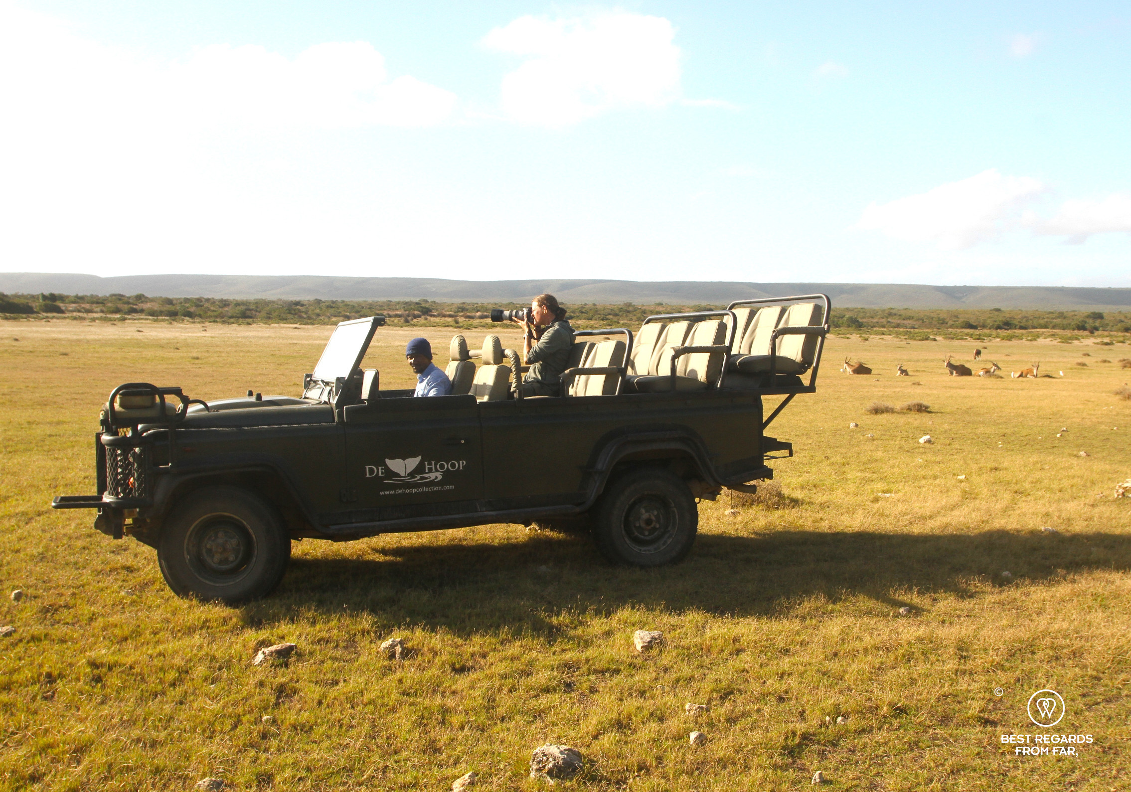 Photographer Marcella van Alphen taking photos from an open game drive vehicle during a private sunset safari at De Hoop Nature Reserve with wildlife in the background.