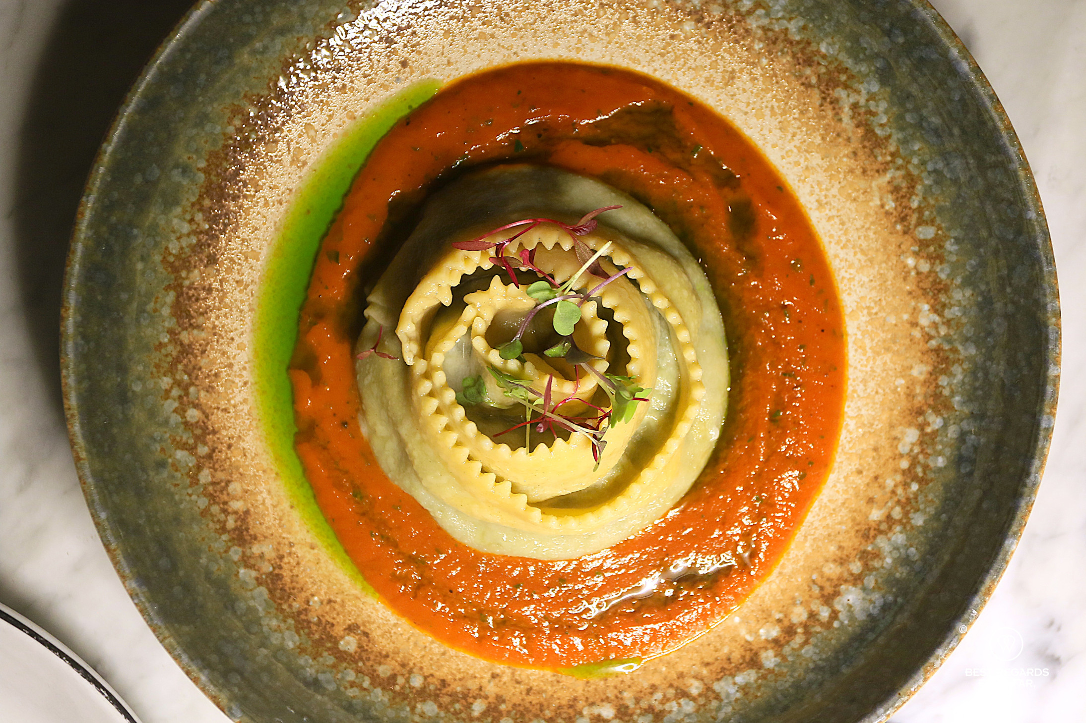 Spinach giuncata rotolini in tomato sauce photographed from the top at Scala restaurant.