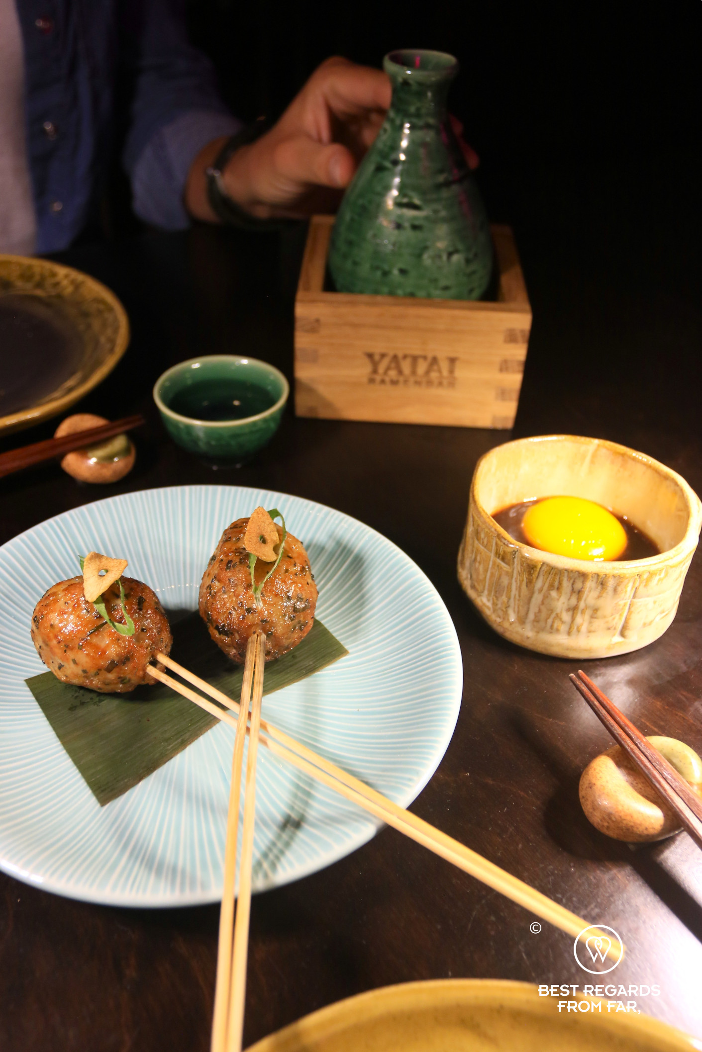 Tsukune with an egg yolk and sake at Yatai ramen bar in Cape Town.