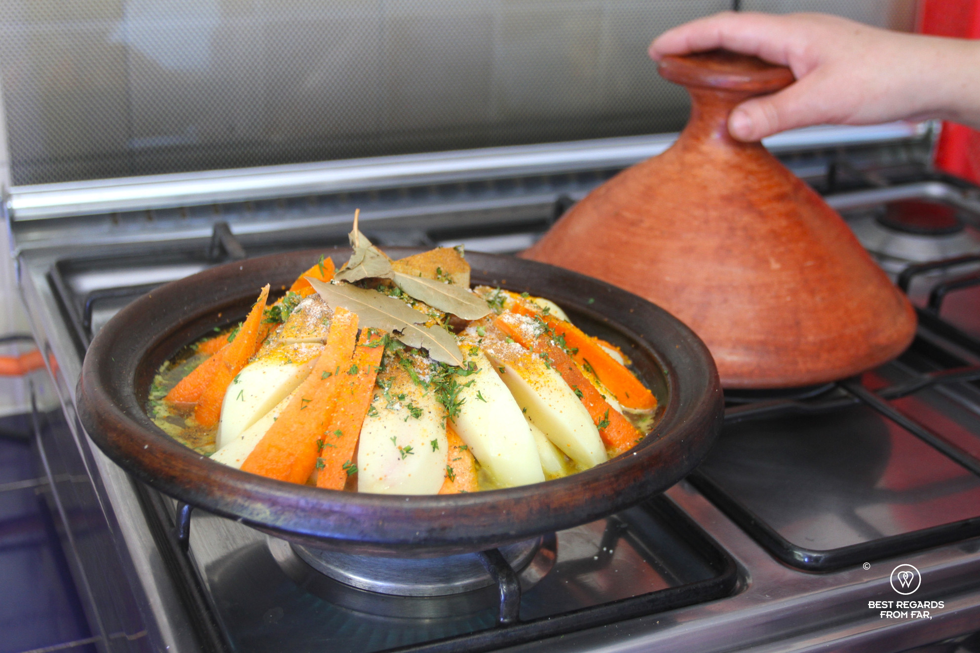 Chicken tajine on a gas stove with vegetables.