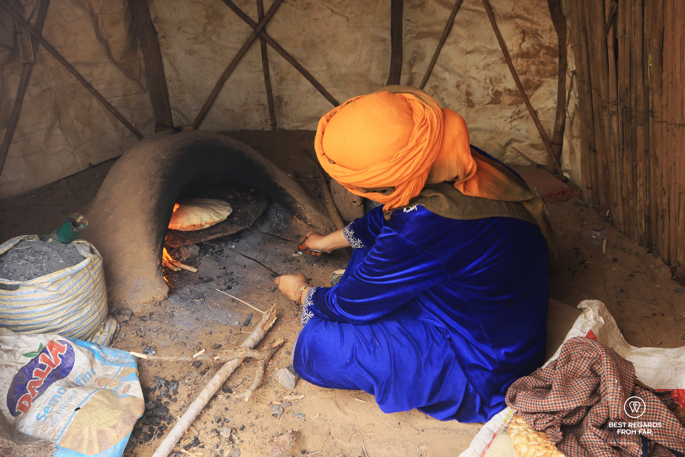 Berber woman baking bread in a tent in the Sahara Desert.