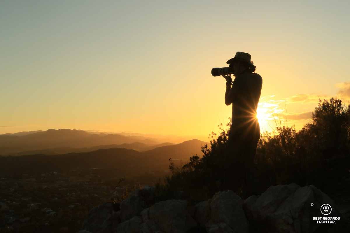 Author Marcella van Alphen taking photographs of layers of mountains at sunrise.