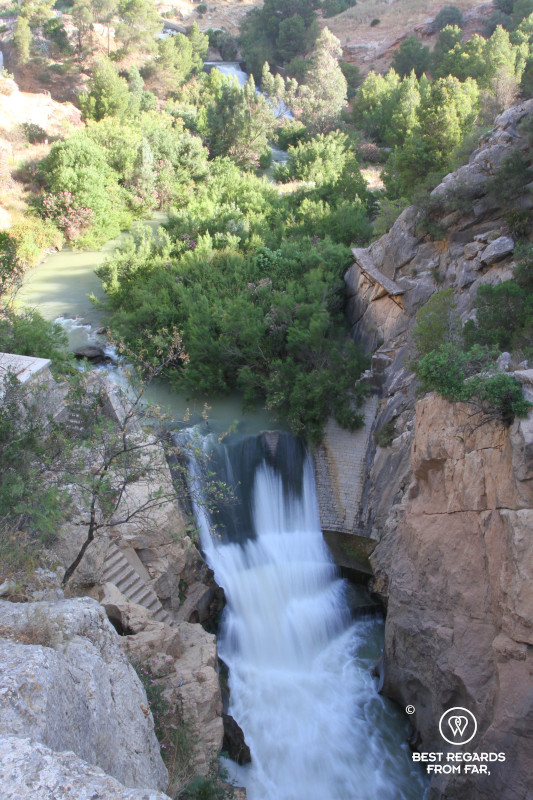 Waterfall over a man-made structure in a canyon taken with a slow shutter speed.