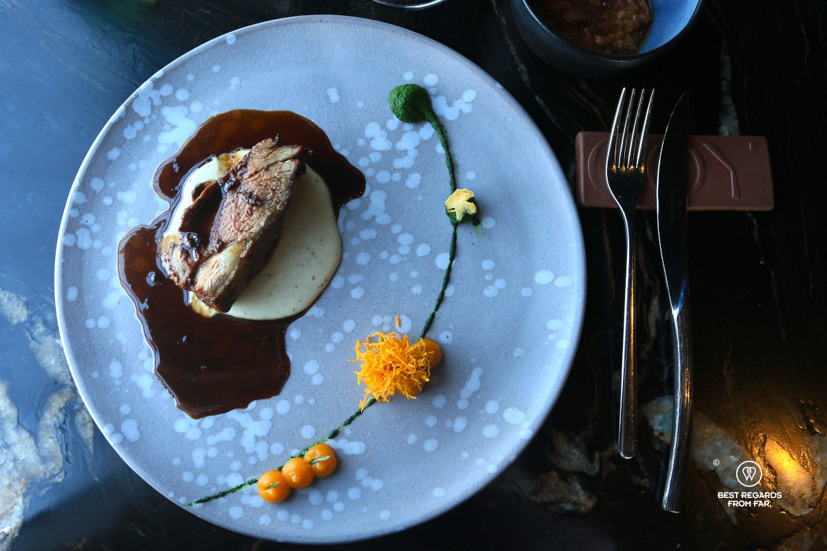 Beautifully plated dish of karoo lamb on mili pap with butternut puree and spinach outer at a fine dining restaurant.