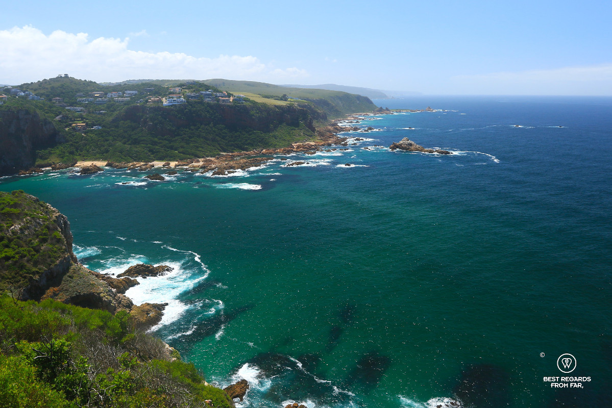 The Knysna Heads from above with the turquoise water of the Indian Ocean and the South African coastline covered in trees.