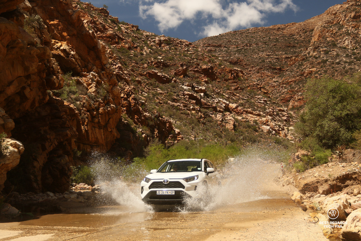 White Toyota 4x4 crossing a stream on the Swartberg Pass in in South Africa.