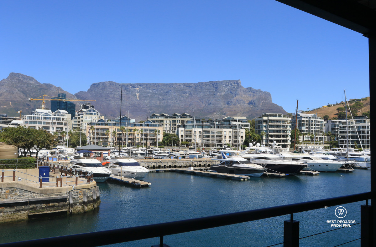 Table mountain behind the marina with some yachts under a blue sky.