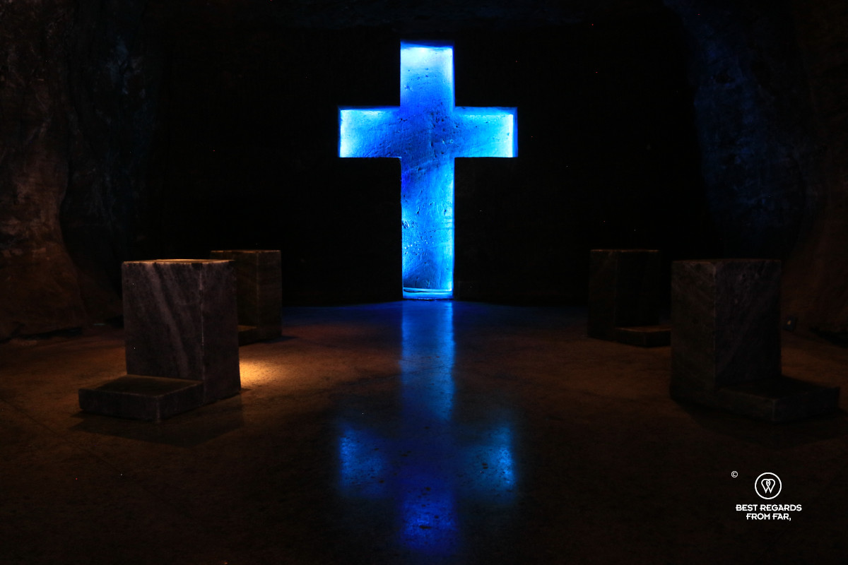 A chapel with a blue backlit carved cross along the station of the cross at the Salt Cathedral.