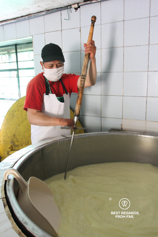 Agosto cutting the curds while making cheese at the Quilotoa Cheese Factory.
