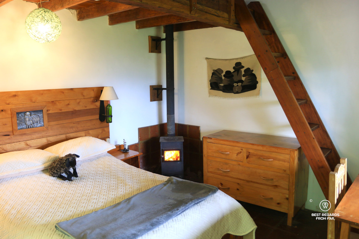 Room with a stove and double bed at the Black Sheep Inn in Chugchilan in Ecuador.