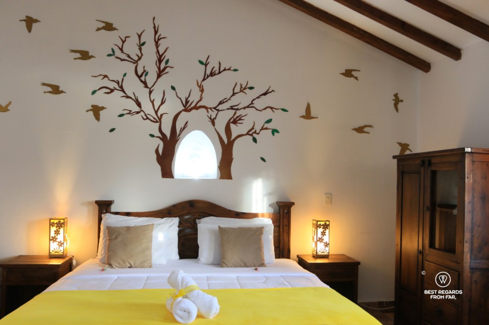 Hotel room with double bed and decorated wall.