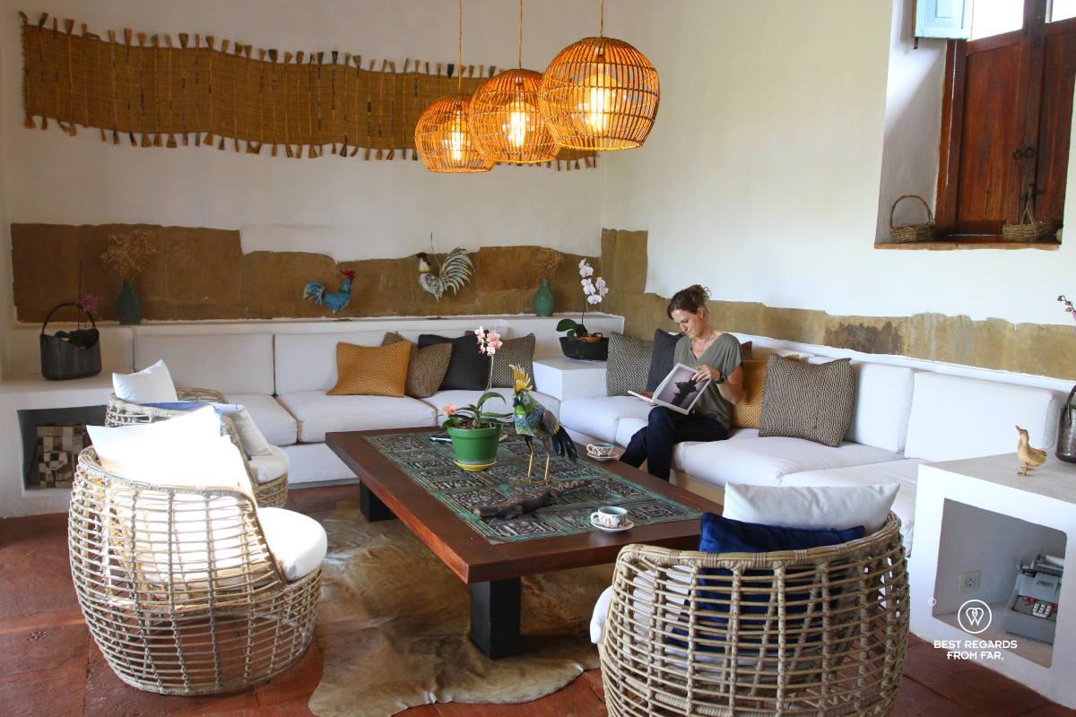 A woman reading a book in the living room of Casa Yahri in Barichara.