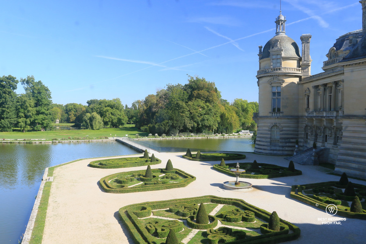 Castle of Chantilly taken from inside the castle with its French garden and water.