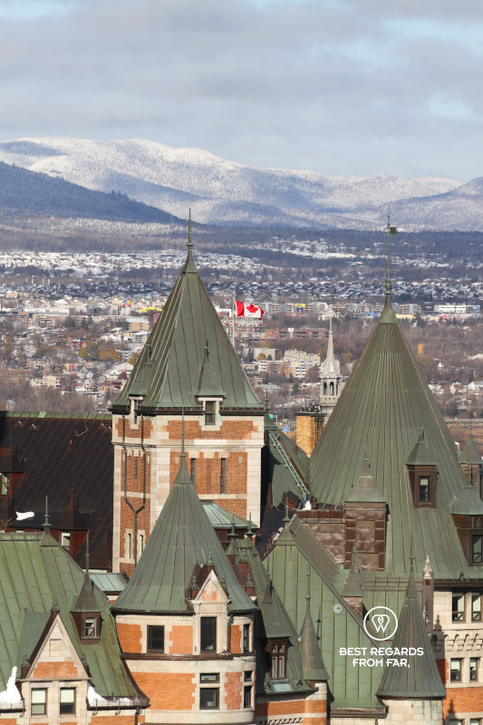 Detail of the Frontenac castle wiht the Canadian flag and the Laurentian Mountains in the background.
