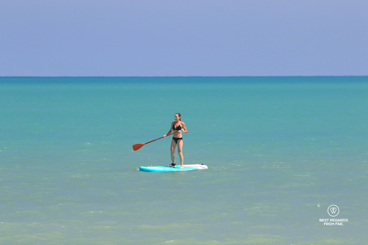 Woman Stand Up Paddling on the blue Caribbean Sea.