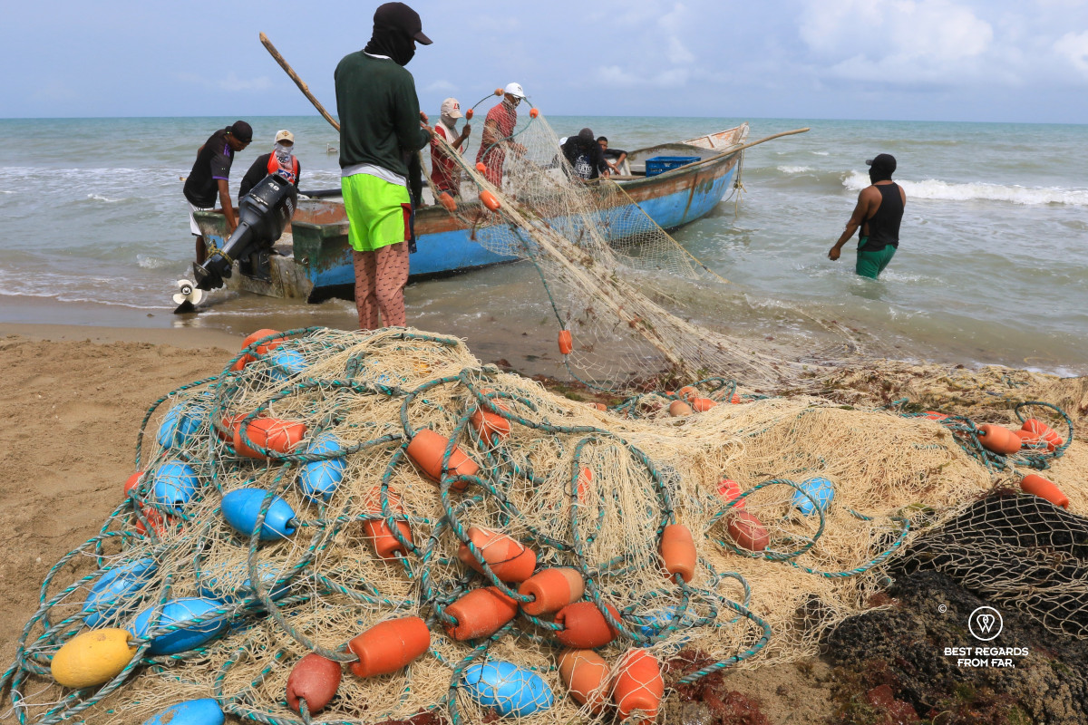 Fishermen pulling their fishing net on their boat.