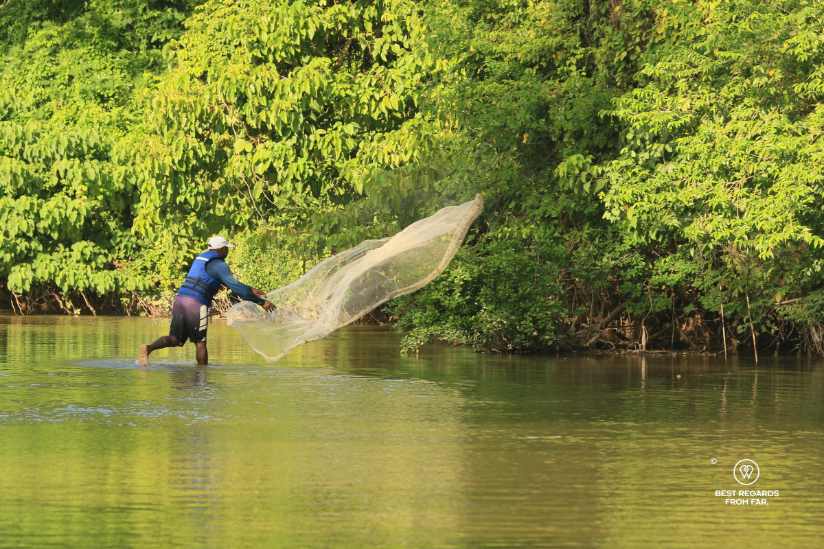 Fisherman throwing a net in a river.