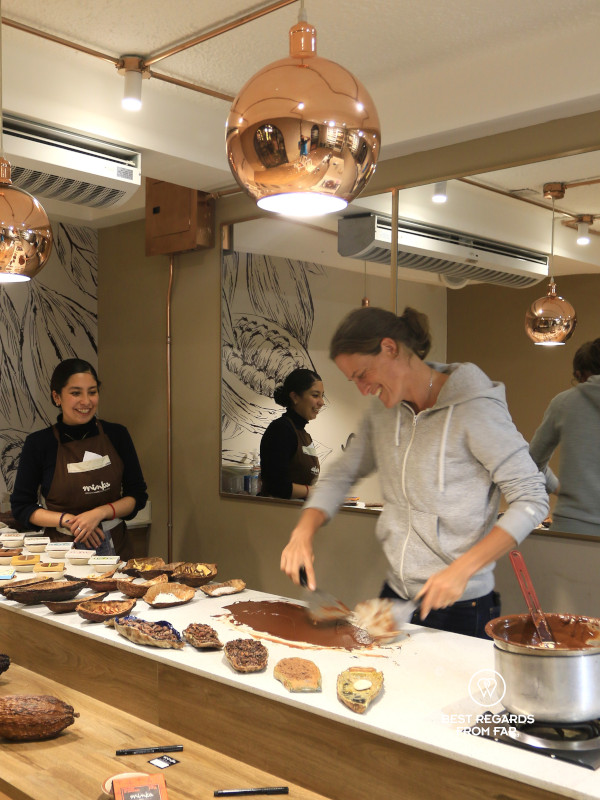 Spreading warm chocolate on a counter during a chocolate bar making workshop in Quito.