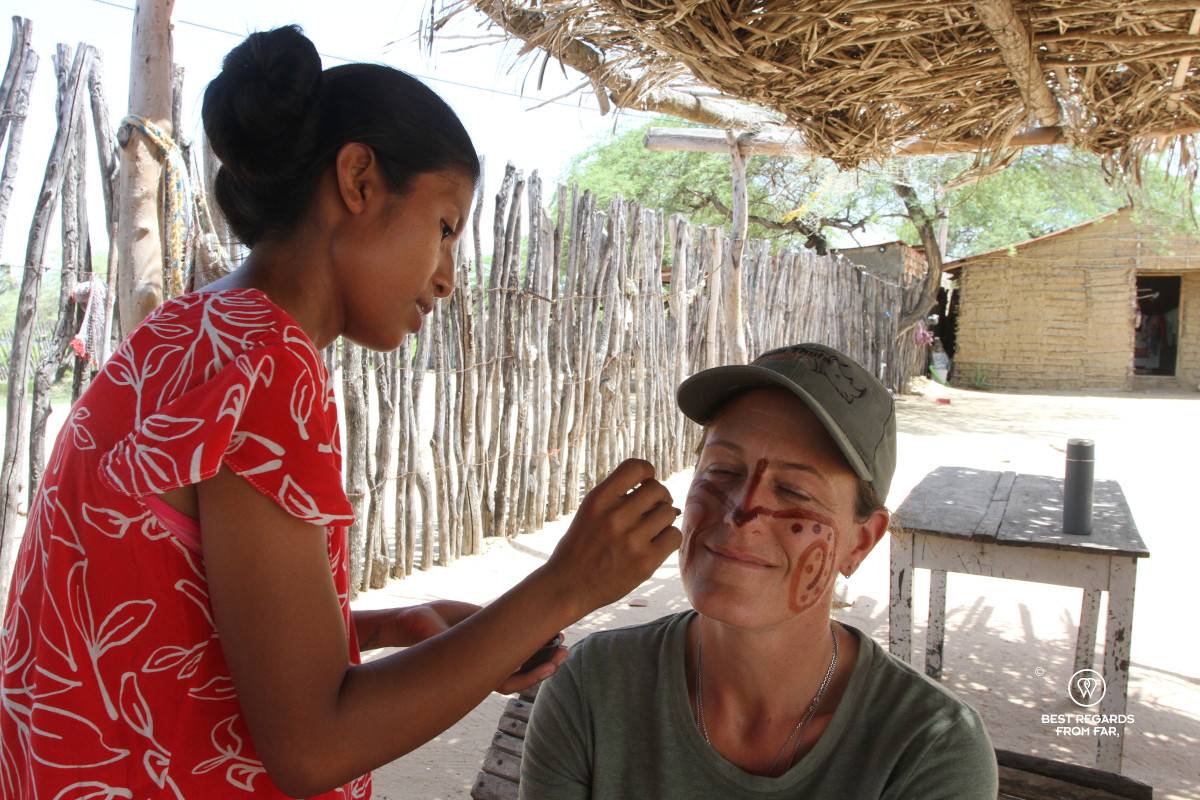 Wayuu woman applying make up to photographer Marcella van Alphen in a rancheria.