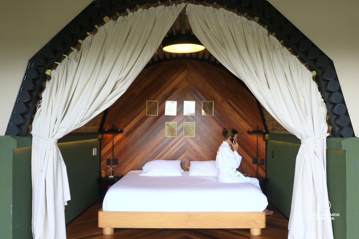 Woman seating on the king-size bed of the bedroom of the Presidential Mush-Room at Bosko.