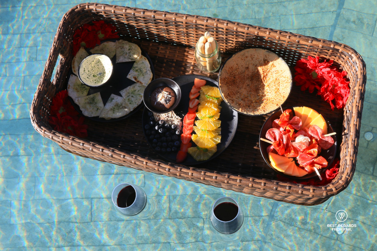 A basket tray and two glasses of wine floating on a pool at Bosko.