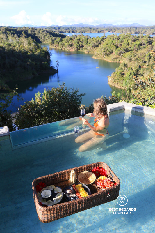 Woman holding a glass on win in a pool with a floating basket tray at Bosko.